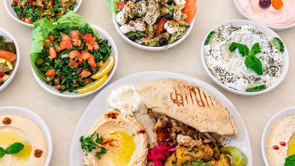 Une table de mezzés, salades, houmous et pains à partager
